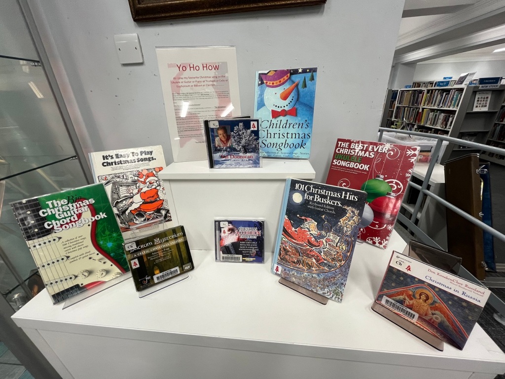 Display of Christmas songbooks and CDs on a table in a library.