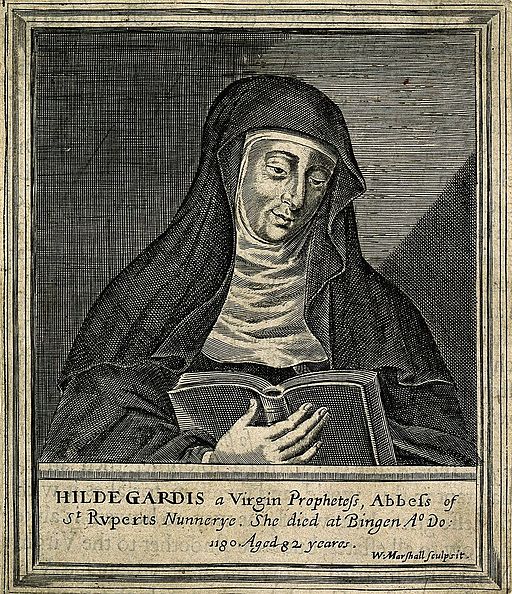 A nun wearing a habit and wimple is reading from a book.