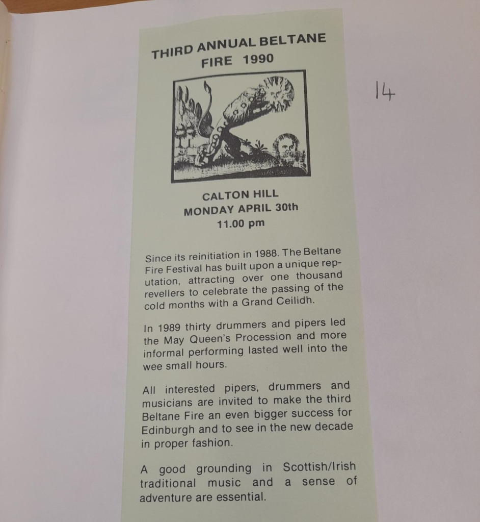 A green coloured paper flyer for the Third Annual Beltane Fire pasted into a page of a volume. 