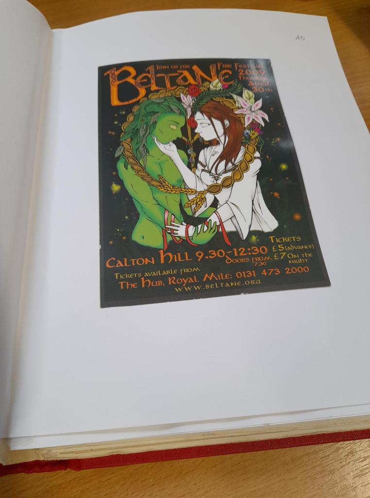 A flyer featuring a green man character and woman in a white dress feature on the 2009 Beltane Fire Festival flyer which is pasted into a bound volume.