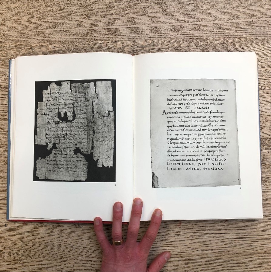 An opened book with an illustration on the left page and latin text on the right.